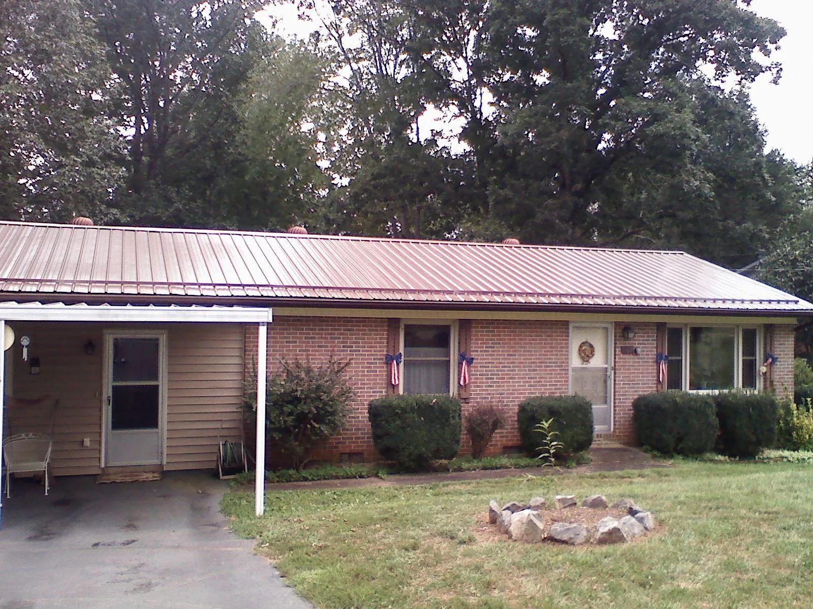 Bronze metal roof and carport on a brick ranch home — Roof Repair work by our crew in Hunter
